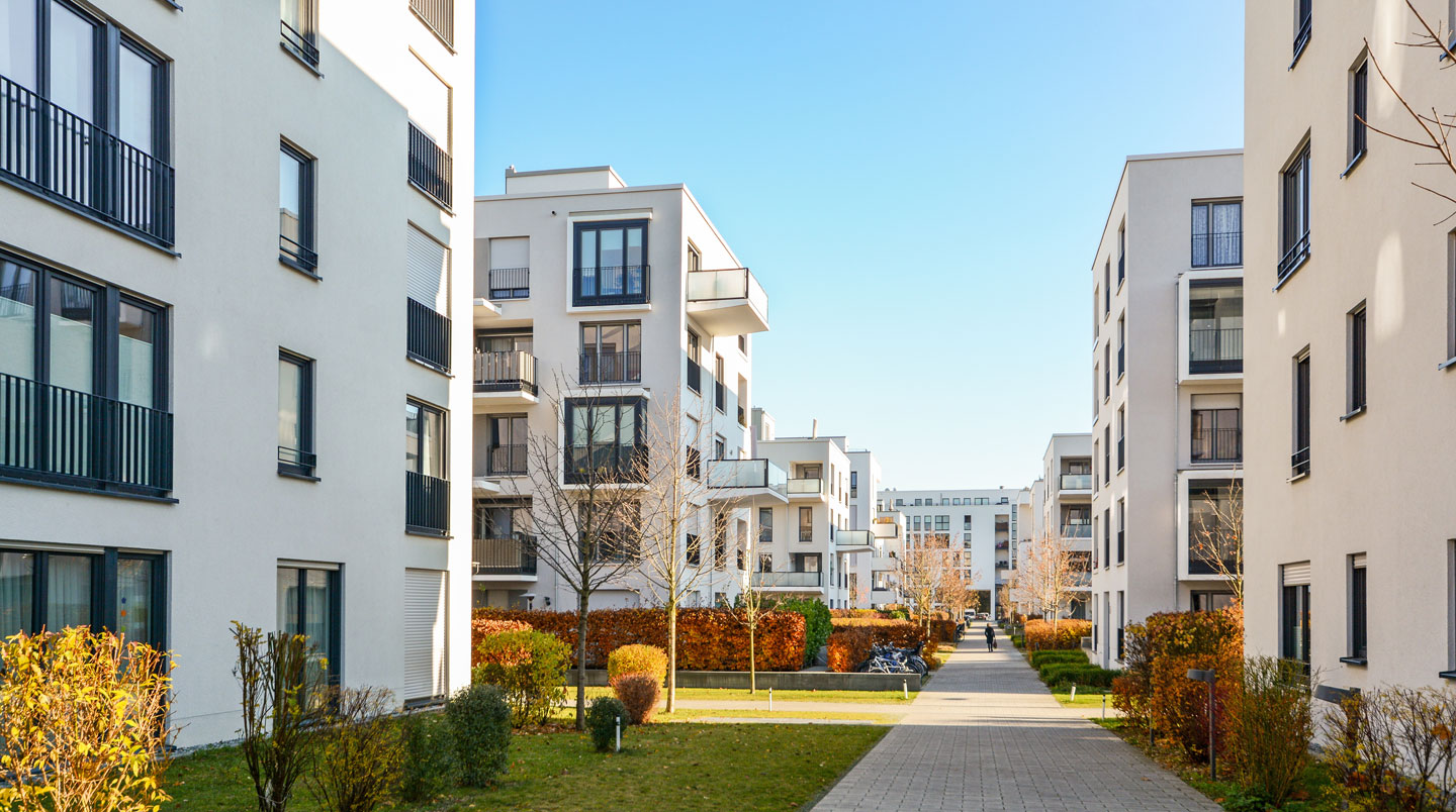 Vue extérieure d'un bâtiment d'EHPAD contemporain en France, avec architecture moderne et jardin arboré au premier plan